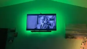 flat screen tv on the wall with green backlighting